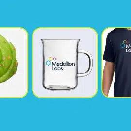A glass cup that is customized with the Medallion Labs logo.